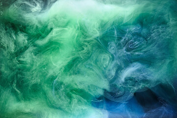 Blue green smoke on black ink background, colorful fog, abstract swirling ocean sea, acrylic paint pigment underwater © amixstudio