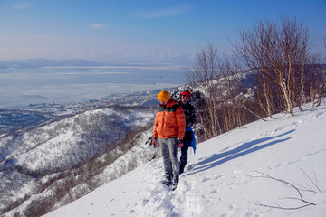 Tourists on a mountain range in winter in Kamchatka