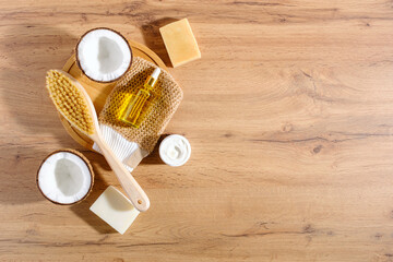 top view eco body and face care, natural soap, dry massage brush, cream, oil on wooden background