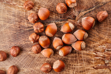 Heap of hazelnuts in shell isolated on wooden background
