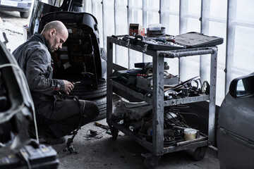 Car service worker repairs restores car