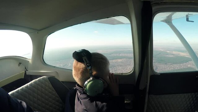 Flying in a small light plane. A man father with a boy child in the cabin of light small aircraft airplane