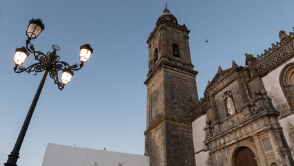 Fototapeta na wymiar Church of Santa Maria la Mayor, Medina Sidonia, Cadiz. Street lamp. Building 