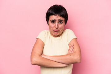 Obraz premium Young caucasian woman isolated on pink background shrugs shoulders and open eyes confused.