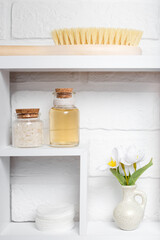 The concept of cleanliness, natural cosmetics, home space organization. Cosmetic organic self-care products on a shelf in the bathroom against a light white wall