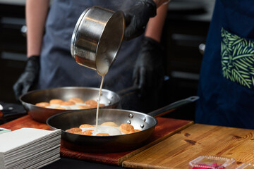 the chef prepares a dish of fish balls in a creamy sauce