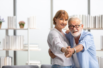 senior couple, elderly man and woman dancing together at home