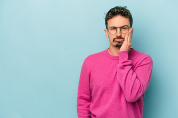 Young caucasian man isolated on blue background who feels sad and pensive, looking at copy space.