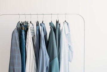 Rack with capsule clothes in blue colors closeup