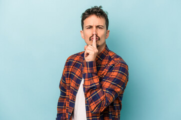 Fototapeta premium Young caucasian man isolated on blue background keeping a secret or asking for silence.