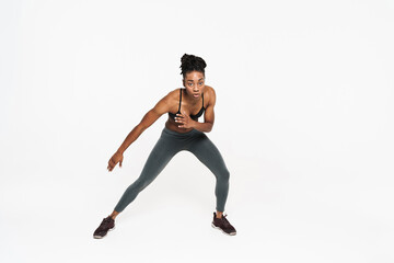 Young black sportswoman doing exercise while working out