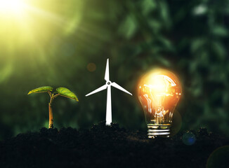 Light bulb is located on the soil, and plant are growing with wind turbine. Renewable energy...