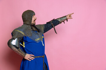 Side view portrait of man, medieval warrior or knight in chain armor pointing, giving instructions...