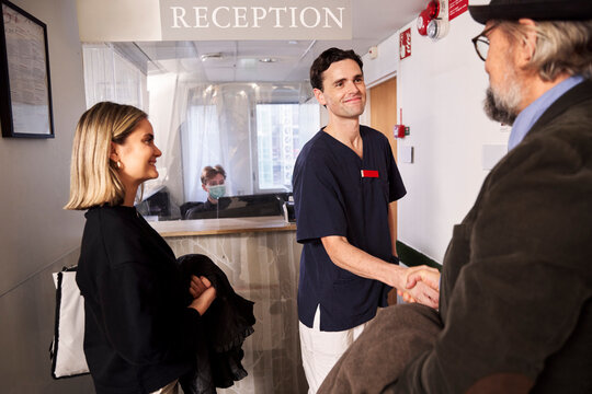 Patients and doctor at reception desk