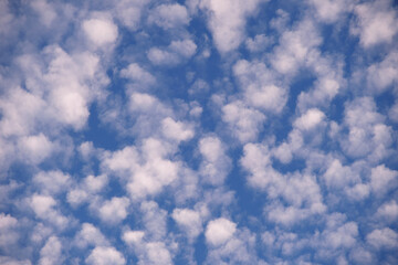 Bright landscape of white puffy clouds spread on blue clear sky