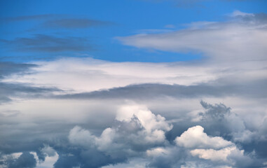 Fototapeta na wymiar Bright landscape of white puffy cumulus clouds on blue clear sky