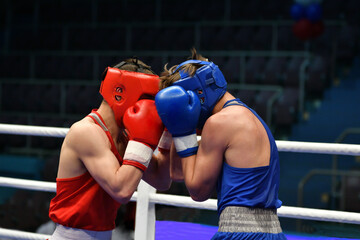 Two young boxers compete in a boxing ring 