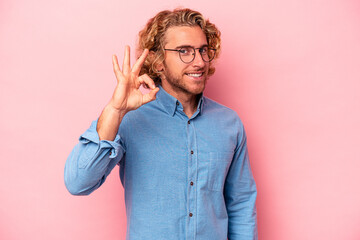 Young caucasian man isolated on pink background cheerful and confident showing ok gesture.