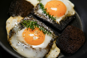 Fried eggs prepared in bread on frying pan 