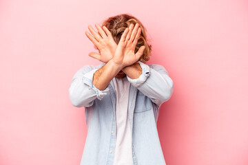 Young caucasian man isolated on pink background keeping two arms crossed, denial concept.