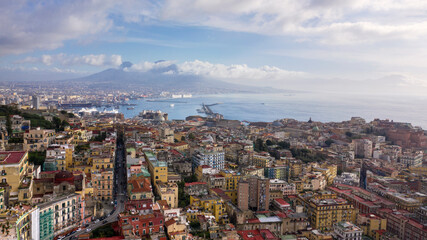 Aerial view of the city of Naples and the harbour on a sunny day. The volcano Vesuvius in the background.