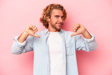 Young caucasian man isolated on pink background showing thumb down, disappointment concept.