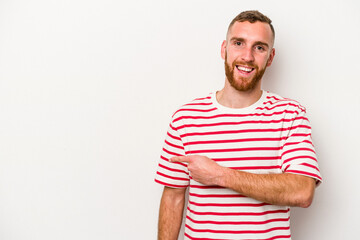 Fototapeta premium Young caucasian man isolated on white background smiling and pointing aside, showing something at blank space.