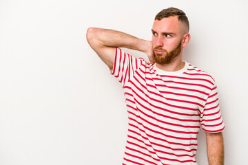 Young caucasian man isolated on white background touching back of head, thinking and making a choice.