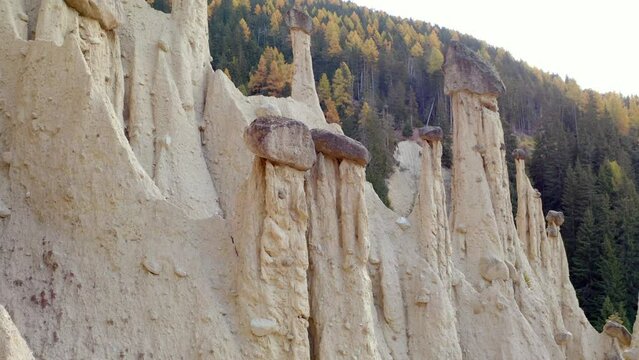 4k drone flight up footage (Ultra High Definition) of Earth pyramids of Platten - Spiky sand towers formed by water erosion and accessed by a woodland trail dotted with sculpture.