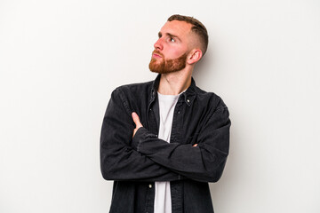 Young caucasian man isolated on white background dreaming of achieving goals and purposes