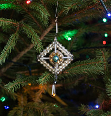 Vintage christmas tree ornament on the pine tree with light garland