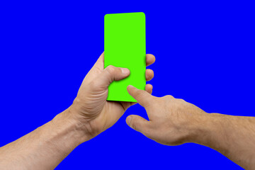 Mobile phone with green chroma key screen for mockup in male hands, the device is positioned slightly turned