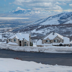 Square White puffy clouds Uphill snowy residential area at Draper in Utah with a view of W