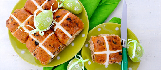 Easter Hot Cross Buns on green polka dot plate on white wood table. Sized to fit popular social...