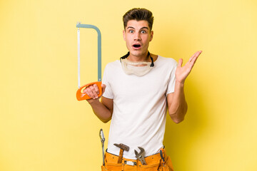 Young electrician caucasian man isolated on yellow background.surprised and shocked.