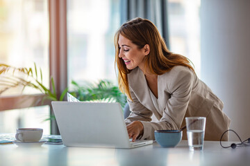 A successful graphic designer watches a tutorial on creative ideas on a laptop computer during the office work process. A positive student with brown hair reads business news on a laptop