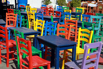 Fototapeta na wymiar Türkiye Bozcaada'da Rengarenk masa ve sandalyeler