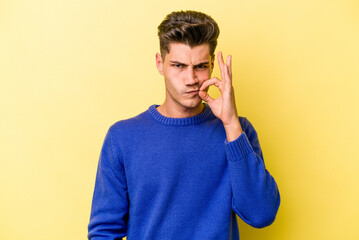 Young caucasian man isolated on yellow background with fingers on lips keeping a secret.