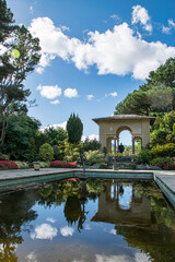 Ein wunderschön angelegter Garten mit einem Torbogen und einem Teich, der die Szenerie spiegelt