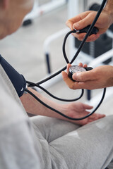 Doctor checking values on blood pressure monitor