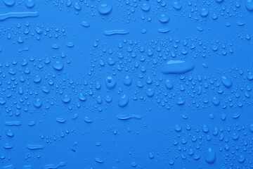 Fototapeta na wymiar Water drops on blue color surface