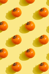 ripe whole persimmon on a yellow background. Pattern