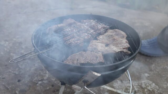 Roast beef and minced meat. Homemade grill with meat and lots of smoke. Slow motion. Full HD video