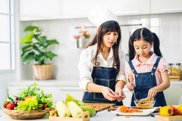 Portrait of enjoy happy love asian family mother and little asian girl daughter child having fun help cooking food healthy eat together with fresh vegetable salad and sandwich ingredient in kitchen
