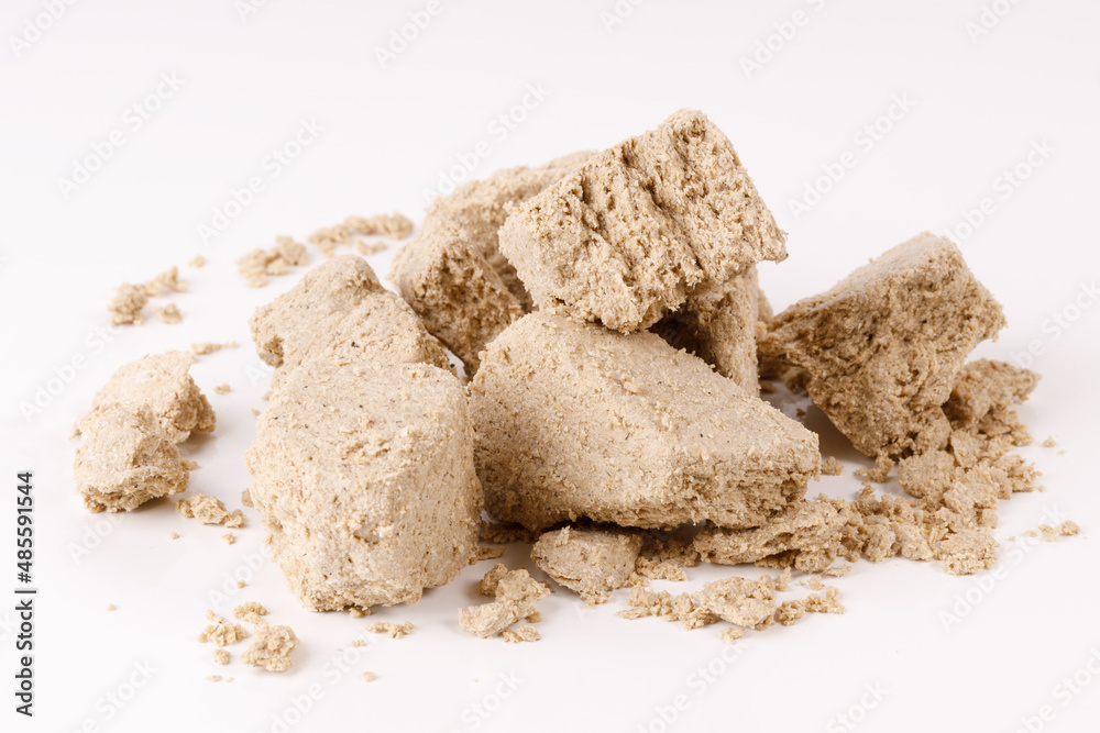 Poster a large pile of halva with crumbs on a white background