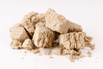 a large pile of halva with crumbs on a white background