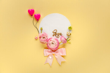 Pink ranunculus decorates the blank postcard on yellow background with balloons. Top view. Mother's day celebration concept. Greeting card. Space for text,  top view.