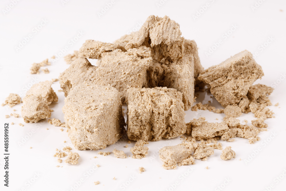 Poster a large pile of halva with crumbs on a white background
