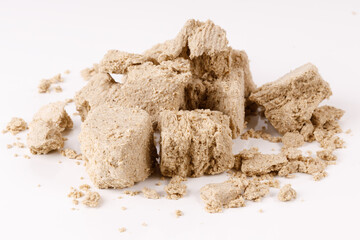 a large pile of halva with crumbs on a white background