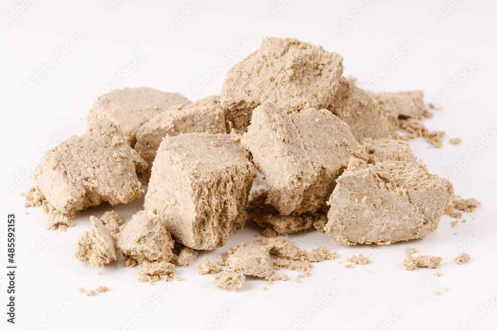Poster a large pile of halva with crumbs on a white background